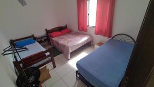 a small room with a bed and a table at Hostel Meu Cantinho Caxambu Mg in Caxambu
