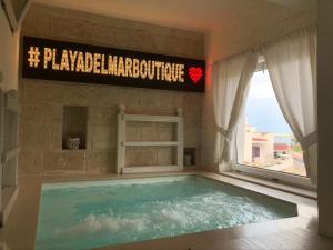 a large swimming pool in a room with a window at Playa del Mar - Adults Only in Monopoli