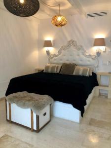a bedroom with a large bed with a black comforter at Playa del Mar - Adults Only in Monopoli