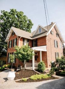 a brick house with a tree in the front yard at Creative Private Attic 1br Suite in Honey Brook