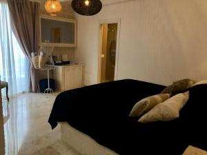 a bedroom with a black bed with pillows on it at Playa del Mar - Adults Only in Monopoli