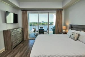 1 dormitorio con cama y vistas a un balcón en Wharf 412, en Orange Beach
