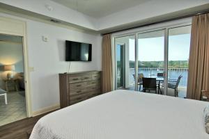 1 dormitorio con cama y vistas al agua en Wharf 412, en Orange Beach