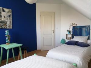 um quarto com 2 camas e uma parede azul em A deux pas de Chambord em Mont-près-Chambord