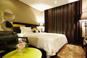 a hotel room with a bed and a couch at Hotel Namoo Cheong-ju in Cheongju