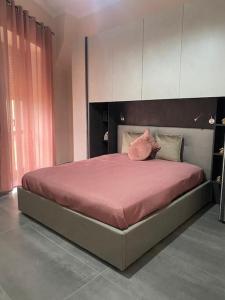 ein Schlafzimmer mit einem großen Bett mit rosa Bettwäsche in der Unterkunft Appartamento in piazzetta in Trecase