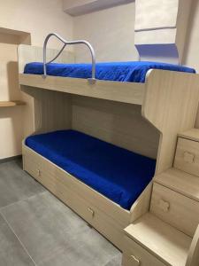 2 Etagenbetten in einem Zimmer mit blauer Bettwäsche in der Unterkunft Appartamento in piazzetta in Trecase
