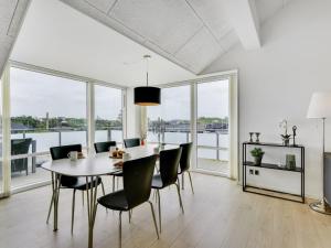 a dining room with a table and chairs and windows at Holiday Home Anneka - 200m from the sea by Interhome in Ringkøbing