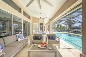 a living room with a couch and a table and a pool at Once Upon A Tide - Cape Coral in Cape Coral