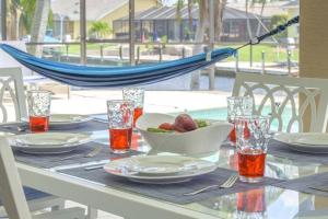 uma mesa com uma tigela de fruta e uma rede de descanso em Once Upon A Tide - Cape Coral em Cape Coral
