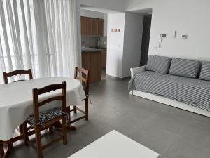 a living room with a table and chairs and a couch at Ninfas Plaza in Puerto Madryn