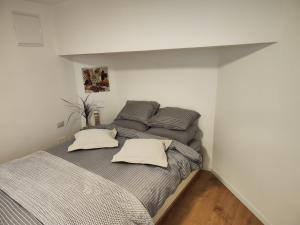 een slaapkamer met een bed met grijze lakens en kussens bij המקום של מוש in Pardes H̱anna