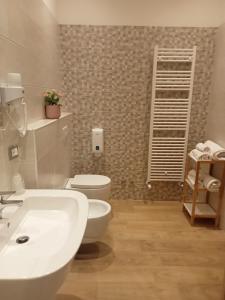 a bathroom with a white sink and a toilet at Hotel Porta Rivera in LʼAquila