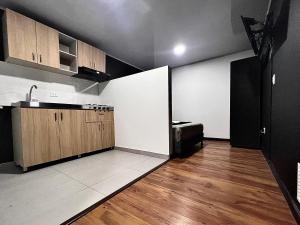 a kitchen with wooden cabinets and a counter top at AW Hotel Ariston Airport in Bogotá +4 photos