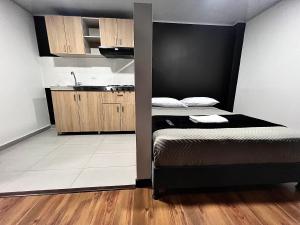 a small bedroom with a bed and a sink at AW Hotel Ariston Airport in Bogotá
