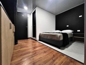 1 dormitorio con 1 cama con paredes negras y suelo de madera en ORANGE CITY HOTEL, en Bogotá