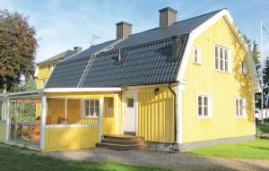 a yellow house with a black roof at Amazing Home In Tidaholm With Kitchen in Tidaholm +18 photos