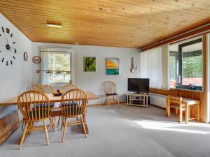 een woonkamer met een tafel en stoelen en een televisie bij Holiday Home Aswaldi - 3-5km from the sea in Western Jutland by Interhome in Blåvand