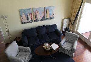 uma sala de estar com um sofá e duas cadeiras e uma mesa em Soling em Laboe