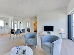 a living room with blue chairs and a table at Apartment Aiana - 250m from the sea by Interhome in Ringkøbing