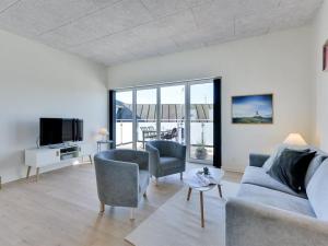 a living room with a couch and chairs and a tv at Apartment Aiana - 250m from the sea by Interhome in Ringkøbing