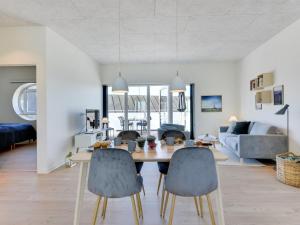 a dining room and living room with a table and chairs at Apartment Aiana - 250m from the sea by Interhome in Ringkøbing