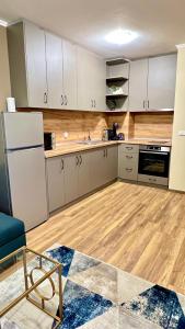 een keuken met witte kasten en een houten vloer bij Gondola Apartments Lux in Bansko