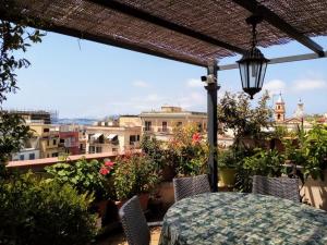 patio ze stołem, krzesłami i kwiatami w obiekcie Il Nido della Quaglia w mieście Pozzuoli
