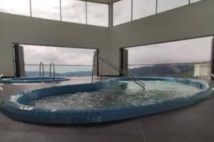 a hot tub in a building with windows at Ammara homestay @ Palas Horizon kea Farm in Brinchang