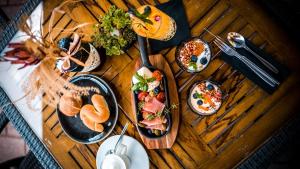 uma mesa de madeira com pratos de comida em Hotel Tihany Átrium em Tihany