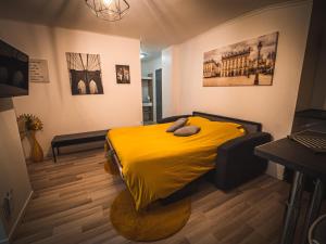 a bedroom with a yellow bed in a room at Le P'tit Jeanne d'Arc in Nancy