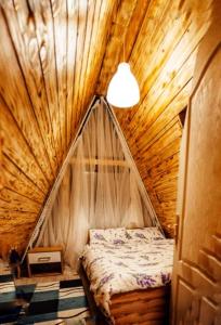 a bedroom with a bed in a wooden tent at CabanaAframe intreaga proprietate in Curtea de Argeş