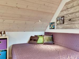 Schlafzimmer mit einem lila Bett und Holzdecken in der Unterkunft Holiday Home Hinz - from the sea by Interhome in Ringkøbing