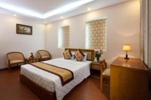 a bedroom with a bed and a table and chairs at Lam Bao Long Hotel in Hue +14 photos