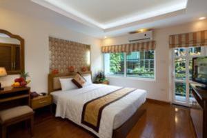 a bedroom with a large bed and a window at Lam Bao Long Hotel in Hue