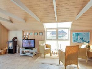 sala de estar con TV, mesa y sillas en Holiday Home Drusilla - 800m from the sea in Western Jutland by Interhome en Hvide Sande