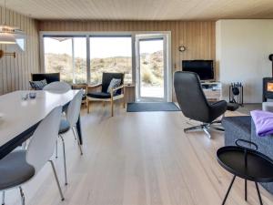 a living room with a table and chairs at Holiday Home Gundine - from the sea in Western Jutland by Interhome in Ringkøbing