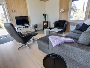 a living room with a couch and chairs and a tv at Holiday Home Gundine - from the sea in Western Jutland by Interhome in Ringkøbing