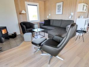 a living room with a couch and a chair at Holiday Home Gundine - from the sea in Western Jutland by Interhome in Ringkøbing