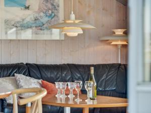 a table with a bottle of wine and glasses on it at Holiday Home Tuure - from the sea in Western Jutland by Interhome in Bjerregård