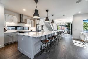 a kitchen with white cabinets and a large island with bar stools at The Rooftop Terrace on the Square in Bentonville