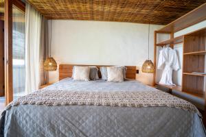 een slaapkamer met een groot bed met 2 kussens bij Villa Kandui Boutique Hotel e Beach Lounge in Barra Grande