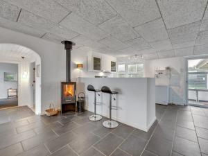 a living room with a fireplace and two black stools at Holiday Home Elia - 300m from the sea in Western Jutland by Interhome in Hvide Sande