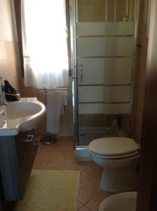 Un baño con inodoro, lavabo y ducha. en Casa Sara&Chiara, en Santa Margherita di Pula