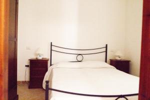 ein Schlafzimmer mit einem Bett und zwei Nachttischen in der Unterkunft Casa Sara&Chiara in Santa Margherita di Pula