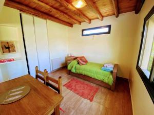 niewielka sypialnia z zielonym łóżkiem i stołem w obiekcie Mountain Charm w mieście Lujan de Cuyo