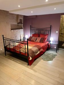a bedroom with a large bed with red pillows at Troglodyte du Petit Coteau in Vouvray