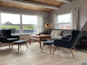 a living room with a couch and two chairs and a table at Holiday Home Arbnora - 400m from the sea in Western Jutland by Interhome in Bjerregård