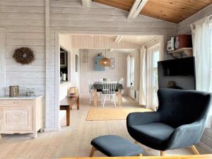 ein Wohnzimmer mit einem Stuhl und einem Tisch in der Unterkunft Holiday Home Arbnora - 400m from the sea in Western Jutland by Interhome in Bjerregård