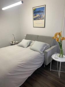 Un dormitorio con una cama y una mesa con un jarrón de flores en Domus Santa Clara Céntrico apartamento con Wifi, en León